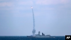 资料照片：中国海军护卫舰滨州号2022年12月27日在东中国海参加与俄罗斯军舰的联合海军演习。（美联社照片）