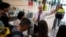 Employees give directions to passengers at a crowded entrance to platforms, at Sants train station in Barcelona, Spain, May 12, 2024. Catalonia's commuter rail service said it was forced to shut down several train lines due to the theft of copper cables.