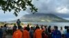 Masyarakat di Sitaro, Sulawesi Utara memandangi gunung berapi Gunung Ruang yang mengeluarkan asap. (Foto: Basarnas via AFP)