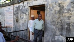 FILE—Prisoners walk after their release at the entrance to the main prison in Moroni, Comoros on May 29, 2019. 