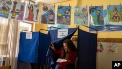 A voter casts her vote at a polling station in Athens, Greece, May 21, 2023. 