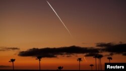 FILE - A SpaceX Falcon 9 rocket carrying 22 Starlink satellites to low-Earth orbit from Space Launch Complex 4 East at Vandenberg Space Force Base streaks over the Pacific Ocean near Encinitas, California, April 1, 2024. 