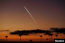 FILE—An evening launch of a SpaceX Falcon 9 rocket carrying 22 Starlink satellites to low-Earth orbit from Space Launch Complex 4 East at Vandenberg Space Force Base is seen over the Pacific Ocean from Encinitas, California, April 1, 2024.