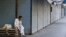 A man sits beside closed shops during a strike against recent price increases, in Karachi, Pakistan, Feb. 27, 2023.