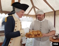 Dan Shippey, who portrays President George Washington at Mount Vernon, tastes Justin Cherry’s hoecakes, which are made from corn. (Deborah Block/VOA)