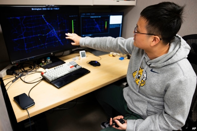 This University of Michigan photo shows Dr. Xingmin Wang, postdoctoral research fellow at the University of Michigan-Ann Arbor, examining data on traffic signals and vehicle flow. (Jeremy Little/University of Michigan College of Engineering via AP)