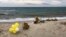 Flowers are left where the wreckage of a capsized boat washed ashore at a beach near Cutro, southern Italy, March 9, 2023. More than 70 people died in a recent shipwreck on Italy's Calabrian coast. 