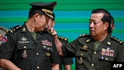 General Hun Manet (L), Commander of the Royal Cambodian Army and eldest son of Prime Minister Hun Sen, reacts as General Eth Sarath (R) touches the four stars on his shoulders during a promotion ceremony in Phnom Penh on April 20, 2023. 