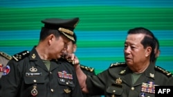 General Hun Manet (L), Commander of the Royal Cambodian Army and eldest son of Prime Minister Hun Sen, reacts as General Eth Sarath (R) touches the four stars on his shoulders during a promotion ceremony in Phnom Penh on April 20, 2023. 