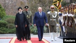 Iranian President Ebrahim Raisi walks with Belarus President Alexander Lukashenko during a welcoming ceremony in Tehran, Iran, March 13, 2023. (BelTA/handout via Reuters)