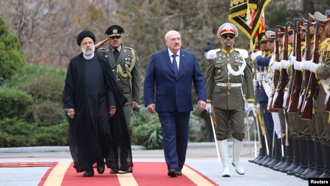 Iranian President Ebrahim Raisi walks with Belarus President Alexander Lukashenko during a welcoming ceremony in Tehran, Iran, March 13, 2023. (BelTA/handout via Reuters)