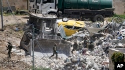 El Ejército israelí opera en la ciudad de Deir al-Ghusun, cerca de la ciudad cisjordana de Tulkarem, el sábado 4 de mayo de 2024. (Foto AP/Majdi Mohammed)