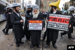 Pengunjuk rasa Yahudi ultra-ortodoks memprotes imbauan wajib militer untuk memperkuat angkatan bersenjata Israel, di Yerusalem, 18 Maret 2024, di tengah konflik Israel-hamas di Jalur Gaza. (AHMAD GHARABLI/AFP)
