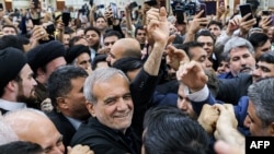 Iran's newly-elected President Masoud Pezeshkian, center, waves to supporters as he visits the shrine of the Islamic Republic's founder Ayatollah Ruhollah Khomeini in Tehran, Iran, July 6, 2024. 