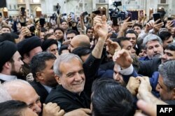 Presiden Iran yang baru terpilih Masoud Pezeshkian, tengah, melambai kepada para pendukungnya saat ia mengunjungi kuil pendiri Republik Islam Ayatollah Ruhollah Khomeini di Teheran, Iran, 6 Juli 2024. (Foto: AFP)