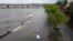 Floodwater pushed by Hurricane Idalia pours over the seawall along Old Tampa Bay as Zeke Pierce of Tampa rides a paddle board, Aug. 30, 2023, in Tampa, Florida. Idalia made landfall earlier Wednesday morning along the Big Bend of the state.