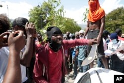 A protester holds up a machete, a symbol of self-defense, during a protest against insecurity in Port-au-Prince, Haiti, Aug. 7, 2023.