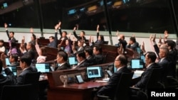 Lawmakers vote during the second reading of Safeguarding National Security Bill, also referred to as Basic Law Article 23, at the Legislative Council, in Hong Kong, March 19, 2024. 
