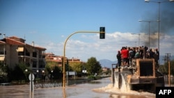 People are evacuated by a Caterpillar excavator from a flooded area in Larissa, central Greece, Sept. 11, 2023. 