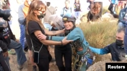 Beatriz Flamini, a Spanish mountaineer who has been isolated for 500 days in a cave, leaves the cave and hugs teammates in Motril, Spain, April 14, 2023, in this screen grab taken from a handout video. (Forta/Handout via Reuters)