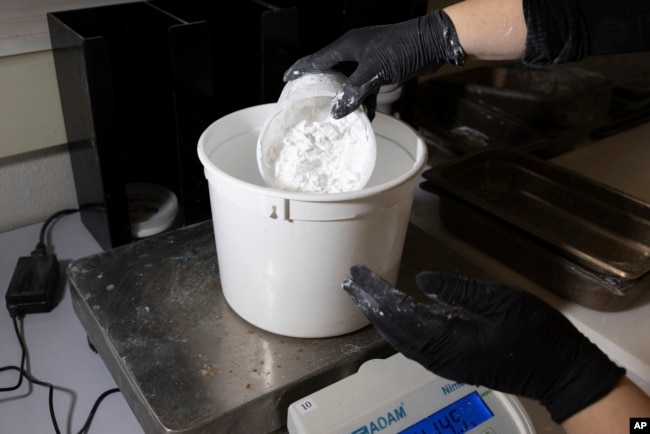 A worker measures ReAct product at Fortera's facility in San Jose, Calif., Wednesday, April 10, 2024. (AP Photo/Benjamin Fanjoy)