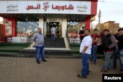 FILE - Syrians wait outside the Shawermat Anas restaurant in Khartoum, Jan. 28, 2016.