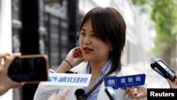 Teresa Xu berbicara kepada awak media di luar pengadilan Beijing setelah persidangan atas kasusnya di mana ia menuntut agar diizinkan untuk membekukan sel telurnya. Persidangan digelar pada 9 Mei 2023. (Foto: Reuters/Florence Lo)