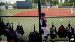 FILE - Graham Bacigalupi, of Team Louisiana, watches from the dugout during the DYB, formerly Dixie Youth Baseball, Little League tournament in Ruston, La., Aug. 8, 2023. Players had to pay close attention to the heat.