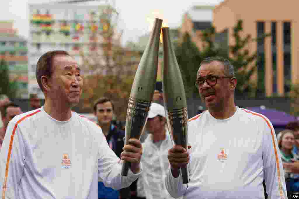 Mantan Sekretaris Jenderal PBB Ban Ki-moon, kiri, dan Direktur Jenderal Organisasi Kesehatan Dunia (WHO) Tedros Adhanom Ghebreyesus ikut ambil bagian dalam estafet obor Olimpiade di Desa Olimpiade di Paris. (AFP)&nbsp;