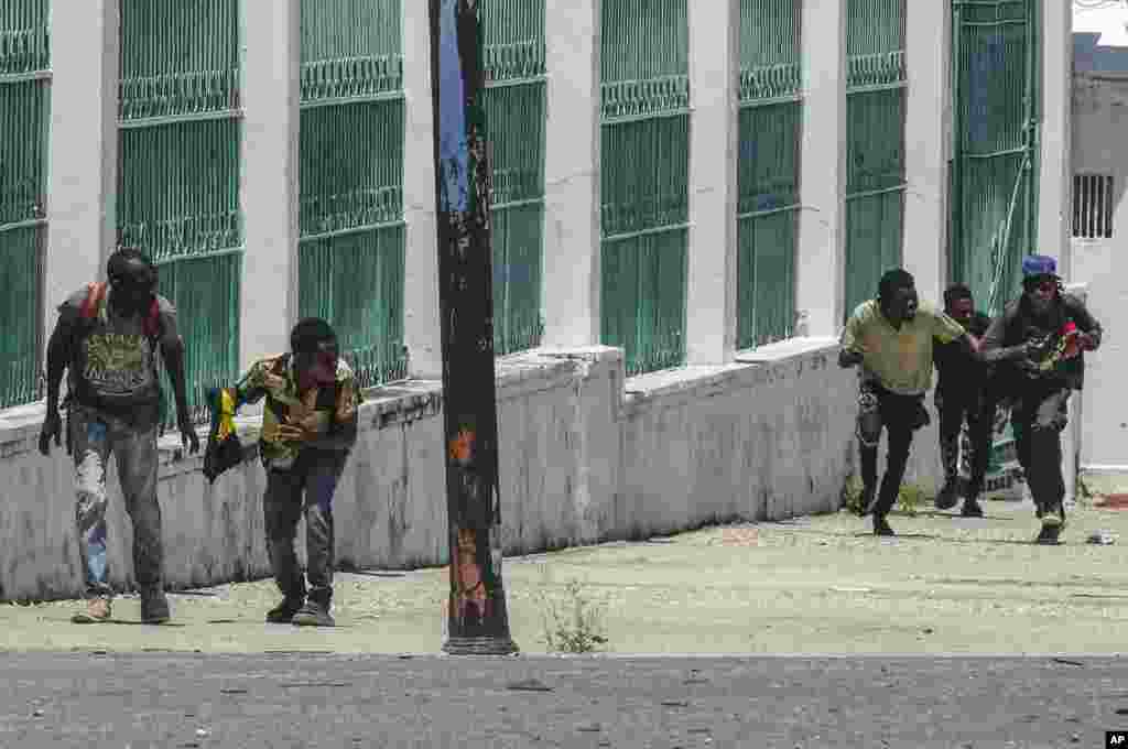 People run for cover as shots ring near the National Palace, in Port-au-Prince, Haiti, April 30, 2024. 