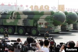 FILE - Military vehicles carrying DF-41 intercontinental ballistic missiles travel past Tiananmen Square during the military parade, Beijing, China, Oct. 1, 2019.