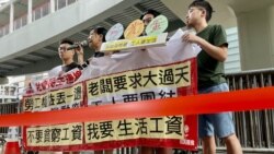香港社民连4名成员，23条立法后首个五一劳动节到政府总部外请愿，在警方以红色胶带围封的示威区内拉横额及发言 (美国之音)