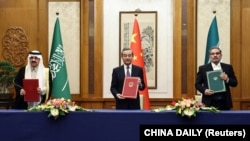 Wang Yi, dari Partai Komunis China (CPC) dan Direktur Kantor Komisi Luar Negeri Pusat saat pertemuan dengan Sekretaris Dewan Keamanan Nasional Tertinggi Iran Ali Shamkhani dan Menteri Negara dan Nasional Arab Saudi Musaad bin Mohammed Al Aiban di Beijing, China 10 Maret 2023. 