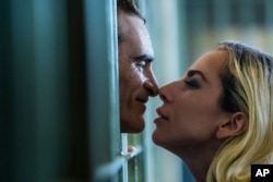 This image released by Warner Bros. Pictures shows Joaquin Phoenix and Lady Gaga in a scene from "Joker: Folie à Deux."