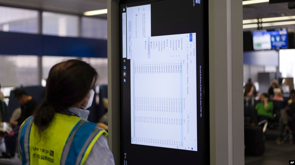 A technician works on an information display near United Airlines gates at Chicago O'Hare International Airport in Chicago, Friday, July 19, 2024. (AP Photo/Carolyn Kaster)