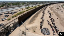 미국 텍사스주 엘파소의 국경장벽 밖에 이송 대기자들이 줄지어 있다. (자료사진)