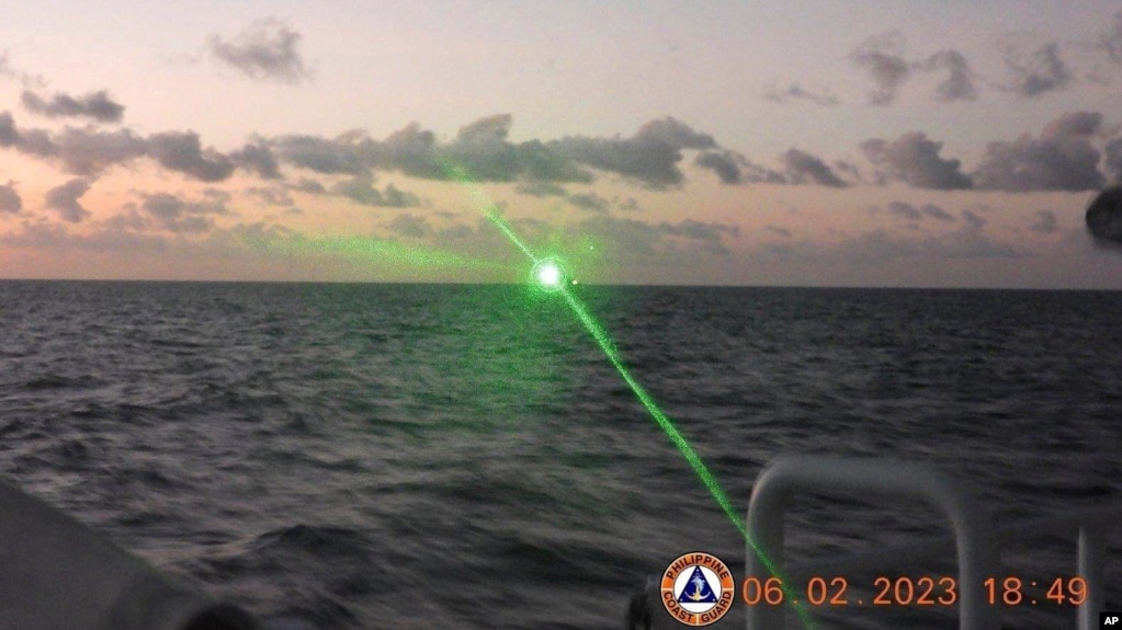FILE - This photo provided by the Philippine Coast Guard shows a green military-grade laser light from a Chinese coast guard ship in the disputed South China Sea, Feb. 6, 2023. 