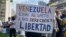 Una mujer muestra un cartel donde exige mejoras salariales al gobierno de Venezuela, durante una movilización por el Día del Trabajador en Caracas, el 1 de mayo de 2024.