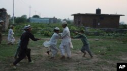 FILE - Students play Kabadi outside a Madrasa during break time in Jammu, India, Sept. 24, 2019.