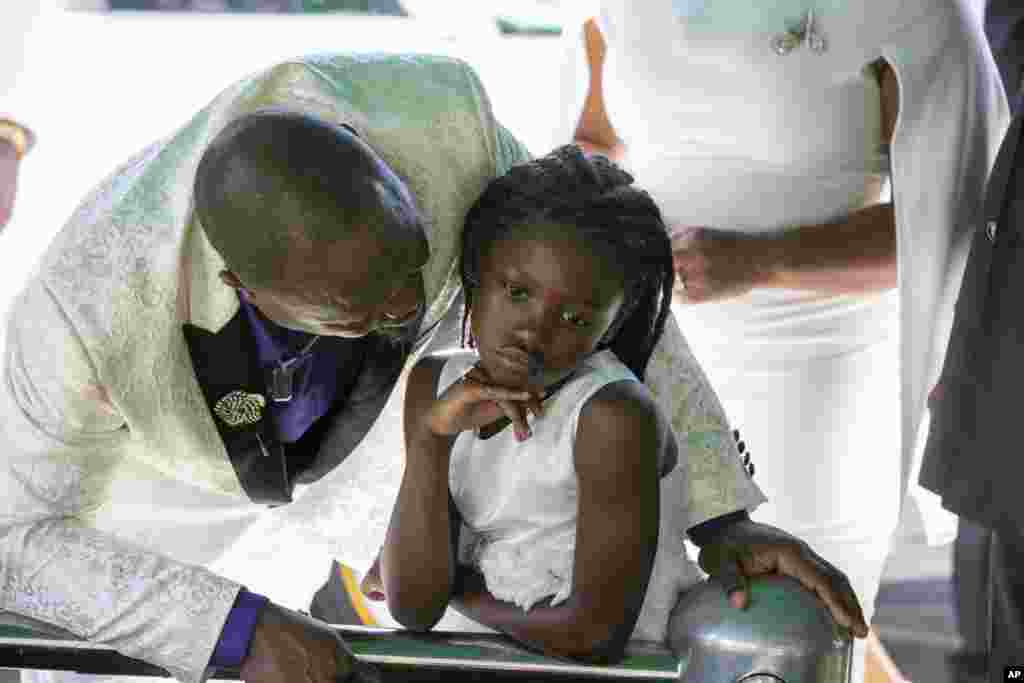 Eddie Owens talks with his daughter, Africa, at the gravesite after the funeral for Africa&#39;s mother, Ajike Owens, at Highland Memorial Park in Ocala, Florida, June 12, 2023.&nbsp;Owens was fatally shot by her neighbor Susan Lorincz when she went to Lorincz&#39;s door. Lorincz was arrested and charged in the shooting.