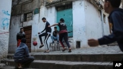 FILE - Children play football in Kasbah of Algiers, a UNESCO World Heritage Site, Algeria, April 11, 2019. 