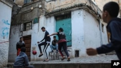 FILE - Children play football in Kasbah of Algiers, a UNESCO World Heritage Site, Algeria, April 11, 2019. 