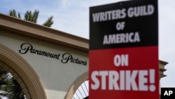 FILE - Members of the The Writers Guild of America picket outside Paramount, May 3, 2023, in Los Angeles. Hollywood productions and promotional tours around the world have been put on indefinite hold as actors and writers are on strike against big studios and streaming services.