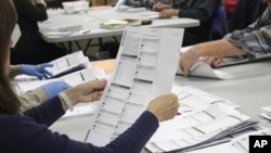 Un trabajador electoral examina una boleta en la oficina de elecciones del condado de Clackamas el jueves 19 de mayo de 2022, en Oregon City, estado de Oregón, EEUU.