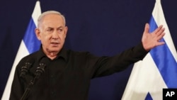 Israeli Prime Minister Benjamin Netanyahu speaks during a press conference with Defense Minister Yoav Gallant and Cabinet Minister Benny Gantz in the Kirya military base in Tel Aviv, Israel, Oct. 28, 2023.