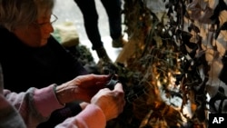 Estonian and Ukrainian women weave the nets from secondhand fabric for the Ukrainian military at the Museum of Occupations and Freedom in Tallinn, Estonia, Feb. 9, 2023.