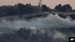 Smoke rises from Israeli artillery shelling in Dahaira, a Lebanese border village with Israel, south Lebanon, as one of the Israeli army positions that was attacked by Hezbollah fighters is seen on the top background, Oct. 16, 2023.