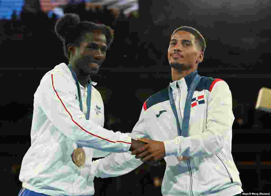 Os medalhistas de bronze David de Pina, de Cabo Verde, e Yunior Alcantara Reyes, da República Dominicana, apertam as mãos na cerimónia de entrega de medalhas.