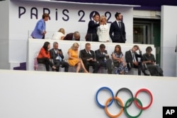 French President Emmanuel Macron talks to his wife Brigitte during the 2024 Summer Olympics closing ceremony at the Stade de France, in Saint-Denis, France, Aug. 11, 2024.