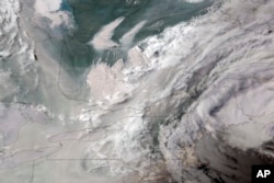 In this GOES-16 GeoColor satellite image taken June 5, 2023 at 7 p.m. EDT and provided by CIRA/NOAA, smoke from wildfires burning in Quebec, Canada, top center, drifts southward. (CIRA/NOAA via AP)
